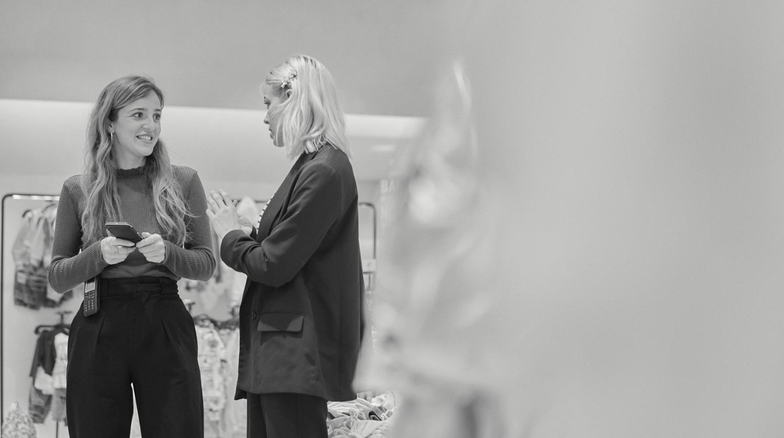 2 workers of Inditex talking in a store. Black and white image