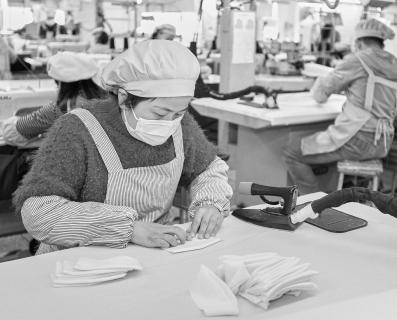 Mujer en una fábrica textil proveedora de Inditex planchando una prenda