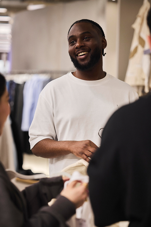 Store employee smiles while chatting with colleagues.