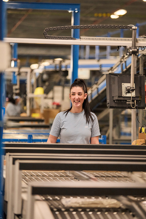 A warehouse worker receives merchandise from our suppliers and places the garments on the distribution carousel