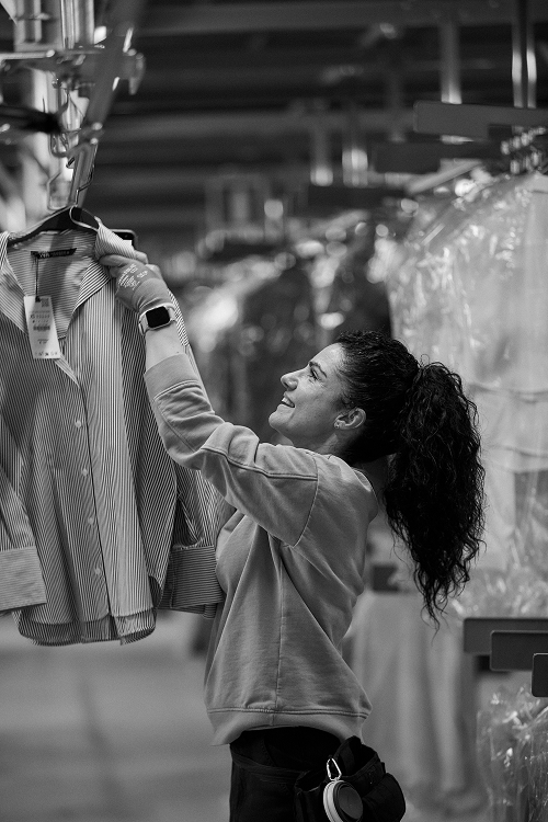 A warehouse worker checks a shirt on the hanging garments carousel at the logistics platform