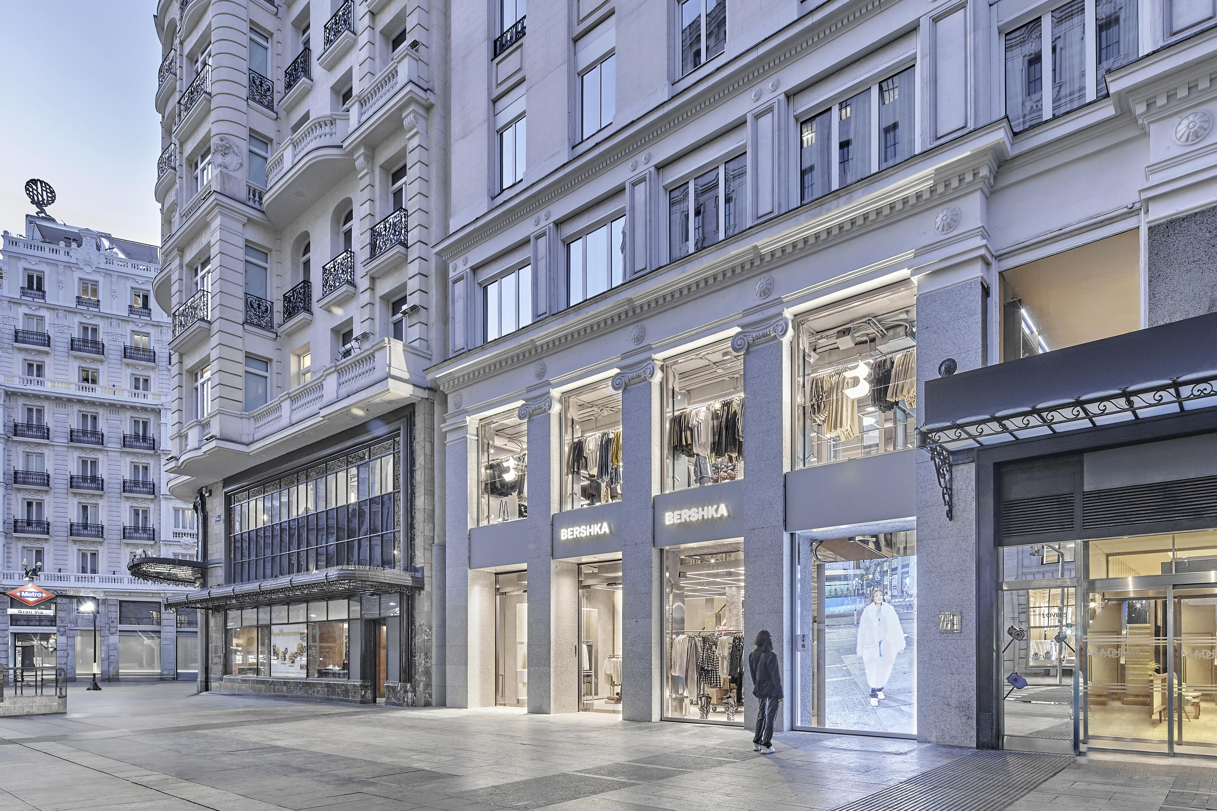 View of the Gran Via avenue in Madrid, showing classic style façades, as well as the main entrance and shopwindows of a Bershka store.