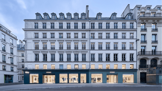 Facade of a classic building with the Oysho store illuminated on the ground floor.