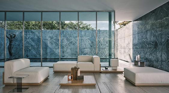 Salón amplio y de estilo minimalista, con grandes ventanales y mobiliarios de Zara Home: sofás blancos y mesas bajas de madera maciza.