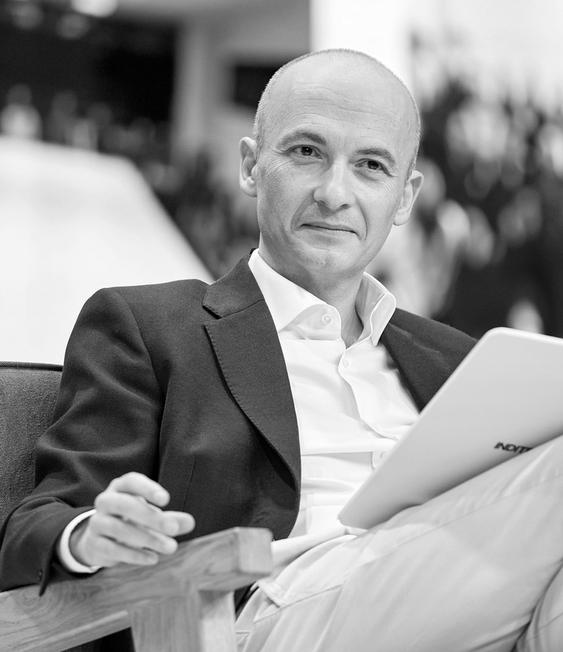 Óscar García Maceiras, CEO of Inditex, smiles while seated on an armchair with a tablet.